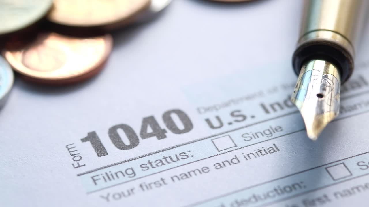 formulario 1040 de impuesto sobre la renta de estados unidos con monedas y bolígrafo