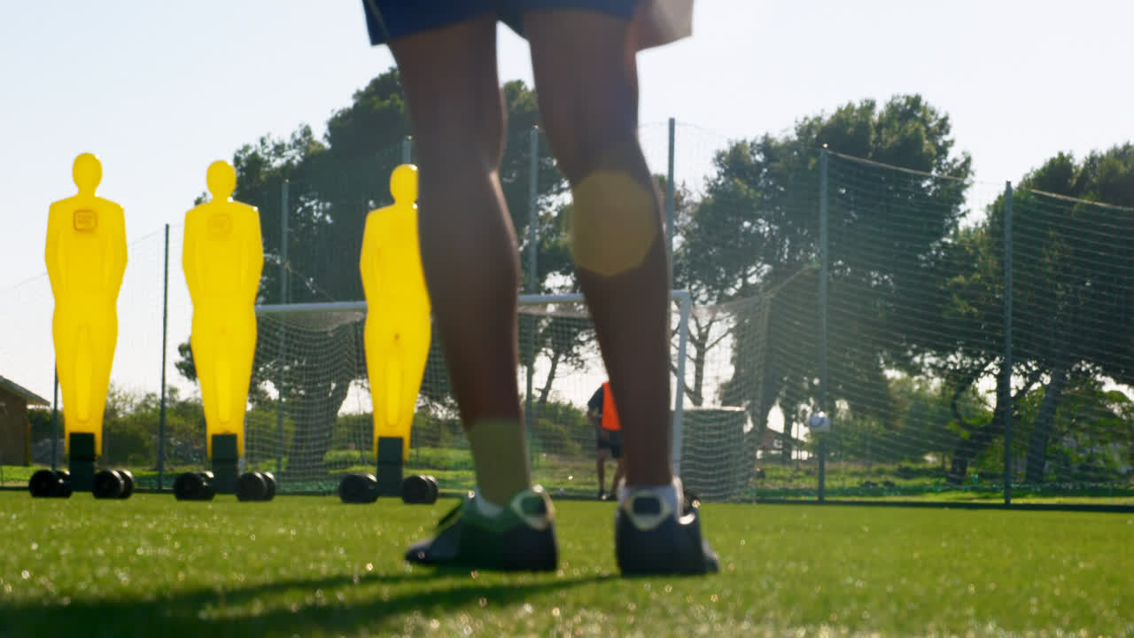골포스트 4k 쪽으로 공을  ⁇ 고 있는 축구 선수