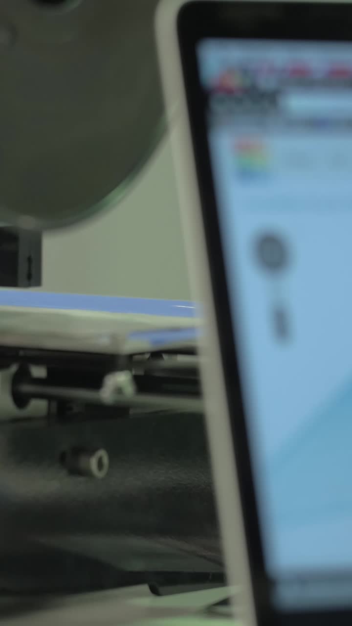 Close-up of 3D Printer Operating with Design on Laptop Screen