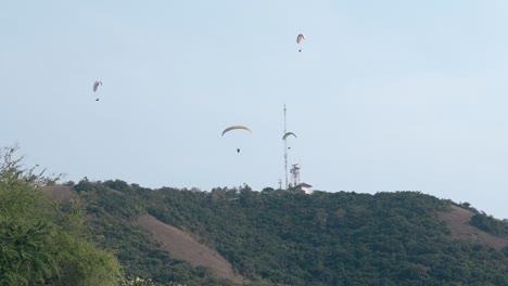 tourists experience extreme sport with parachutes in tropics