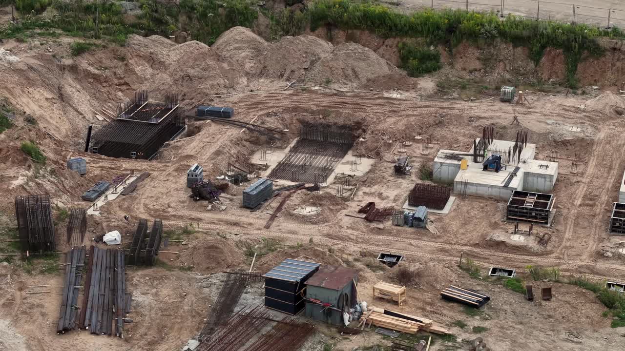Drohnenüberflug der Baustelle des Nationalstadions von Vilnius, der Betonfundamentplatten, Bewehrungskörbe, Schalungen und Erdarbeiten für einen großen städtischen Infrastrukturbau zeigt – 16. August 2025