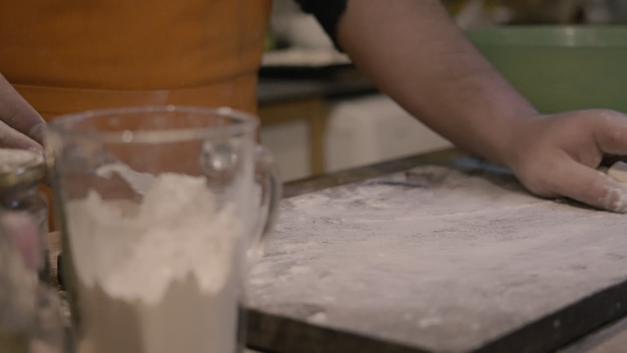 Close-up of Hands Cutting and Shaping Dough on a Floured Board