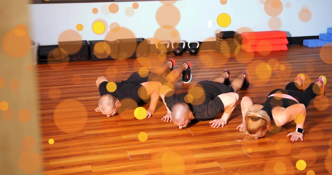 Cvičenci na povel spouštějí hrudník při sérii kliků s kettlebelly pro trénink