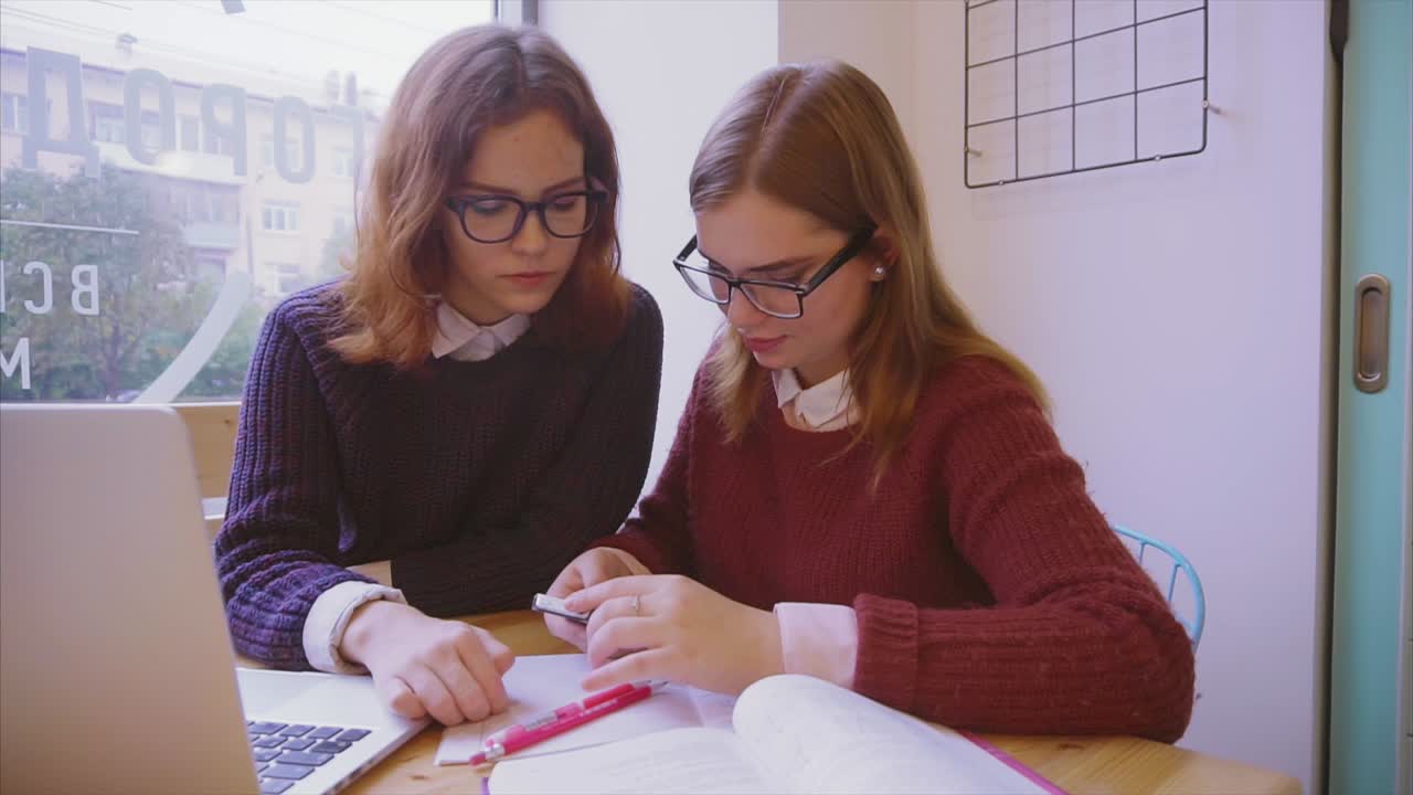 dos estudiantes colaborando en un café