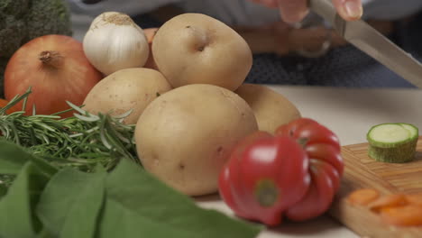 Woman-hands-cutting-zucchini-vegetables,-preparing-meal-in-home-kitchen