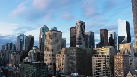 rising aerial of seattle's downtown skyscrapers with light fluffy clouds in the background