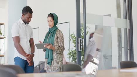 busy diverse business people discussing work with tablet in office in slow motion