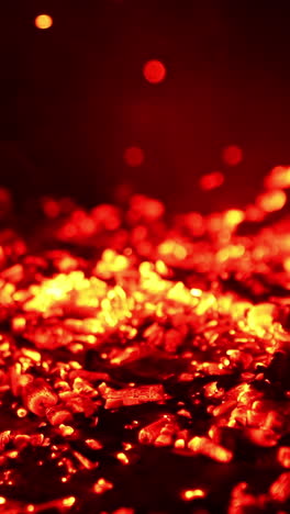 blowing air on the burned charcoal. the pieces of burnt wood start to glow red and smoke goes up. close up. vertical video