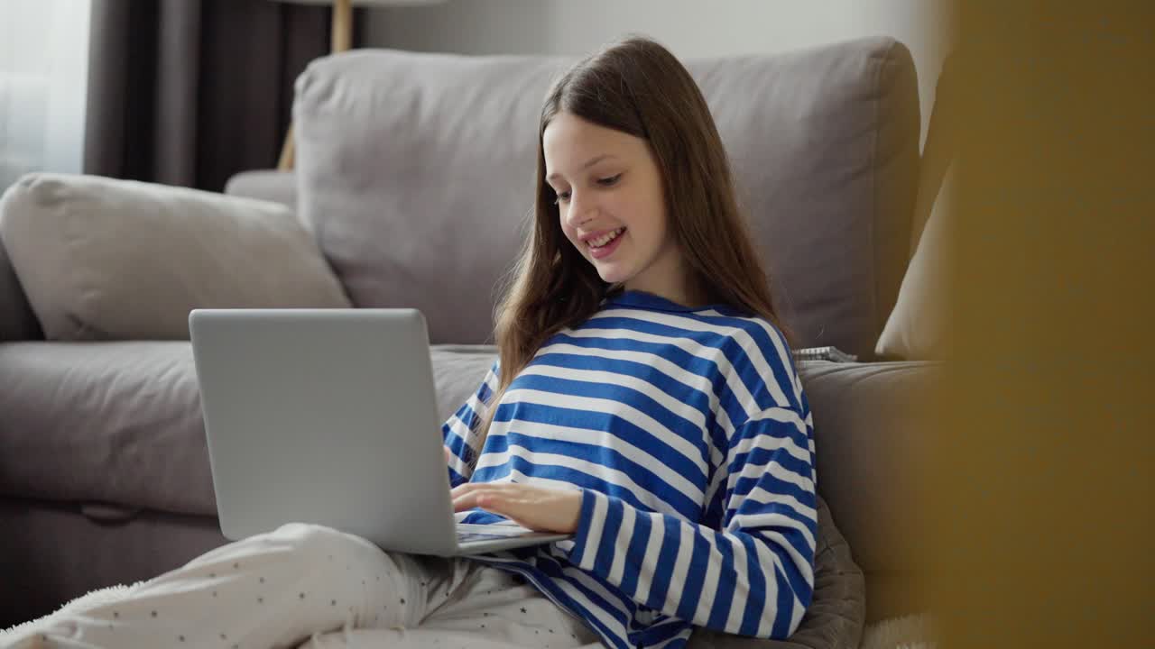 una adolescente usando una computadora portátil en casa