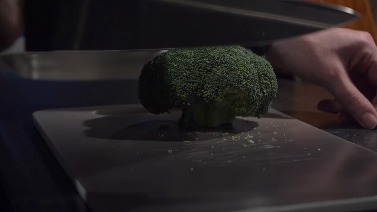 도마에 있는 신선한 브로콜리 머리에서 자른 줄기, 보기를 닫습니다.