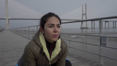 mujer joven centrada en el entrenamiento en el muelle de madera