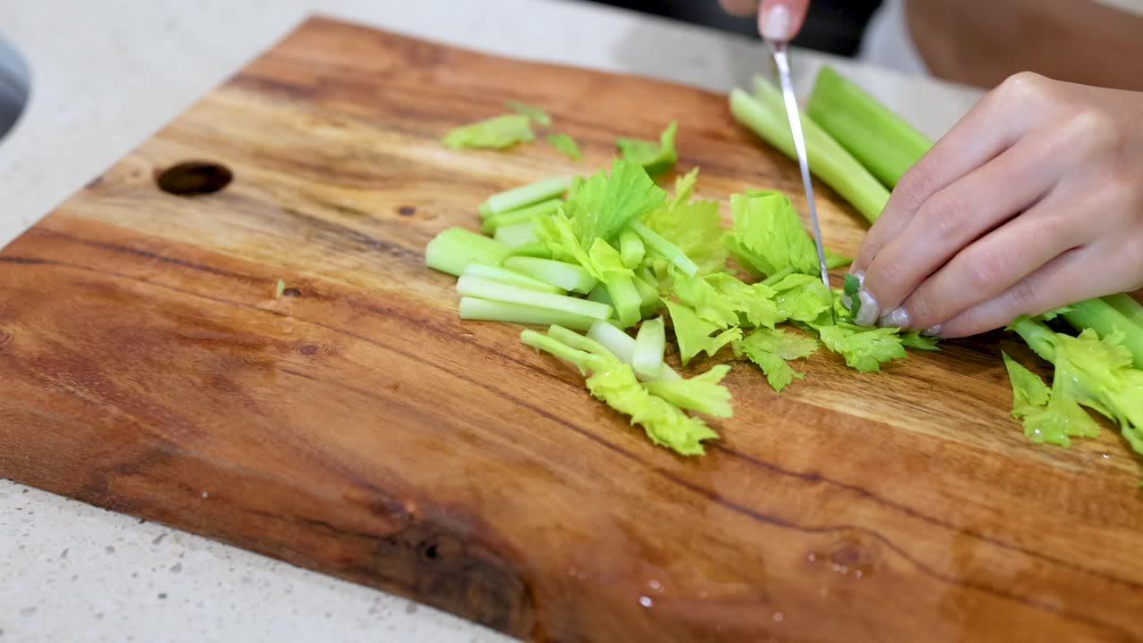 Chopping Celery on a Wooden Cutting Board
