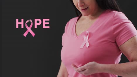 animation of hope text over caucasian woman with pink ribbon on black background