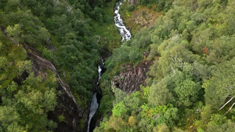 El-Río-Fluye-A-Través-De-Una-Grieta-Rocosa-En-Un-Bosque-Verde,-Noruega,-Europa,-Drone