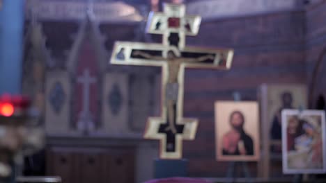 focus pull from a red candle to a cross in an orthodox church