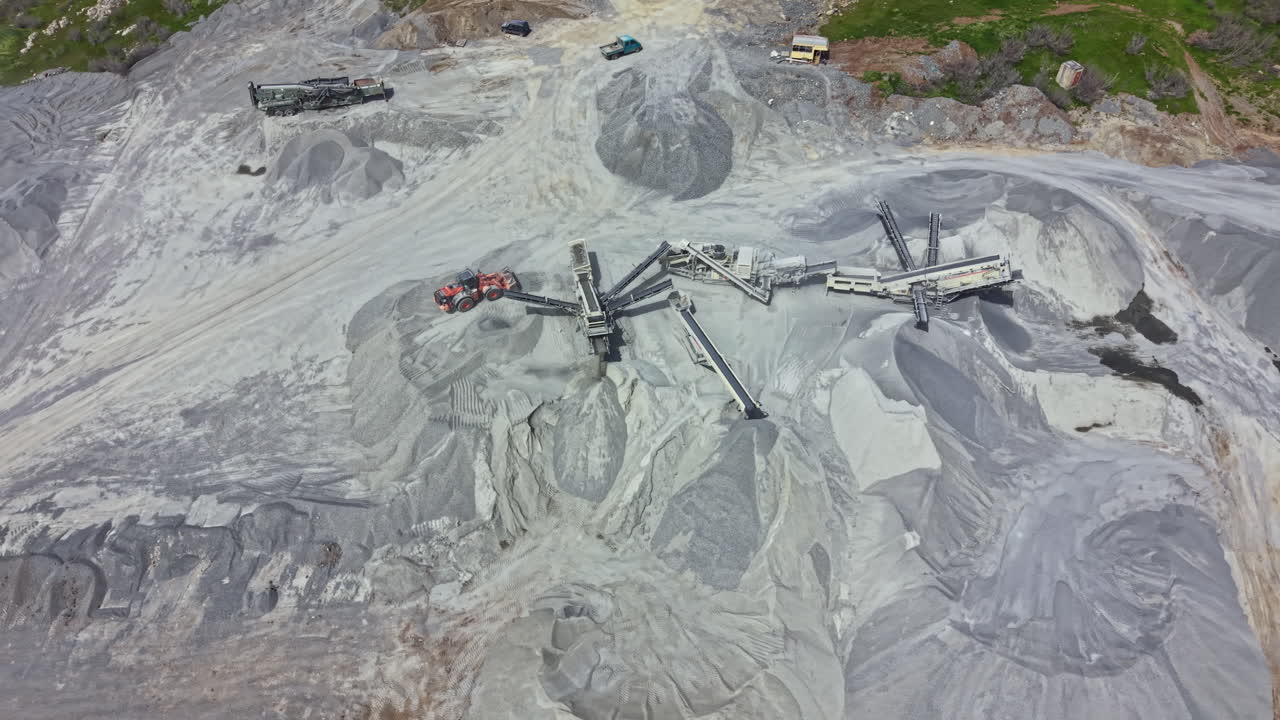 Granite quarry showing machinery, materials, and activity in an industrial setting