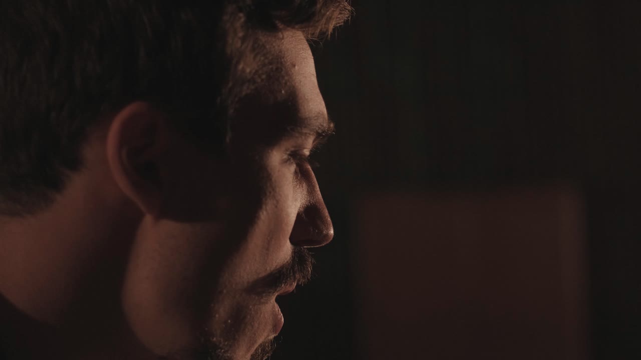 un chico guapo toca una guitarra acústica en un cine abandonado. el músico canta una canción y acompaña en la guitarra