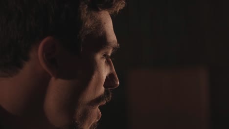 un chico guapo toca una guitarra acústica en un cine abandonado. el músico canta una canción y acompaña en la guitarra