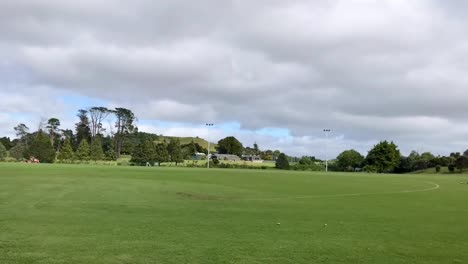 Vehículo-De-Mantenimiento-De-Terrenos-Moviéndose-A-Lo-Largo-Del-Campo-Verde-En-Un-Día-Ventoso-En-Auckland-Nueva-Zelanda---Lapso-De-Tiempo