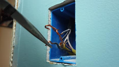 doblar cables de cobre para ayudar a facilitar la instalación de un nuevo interruptor de luz.
