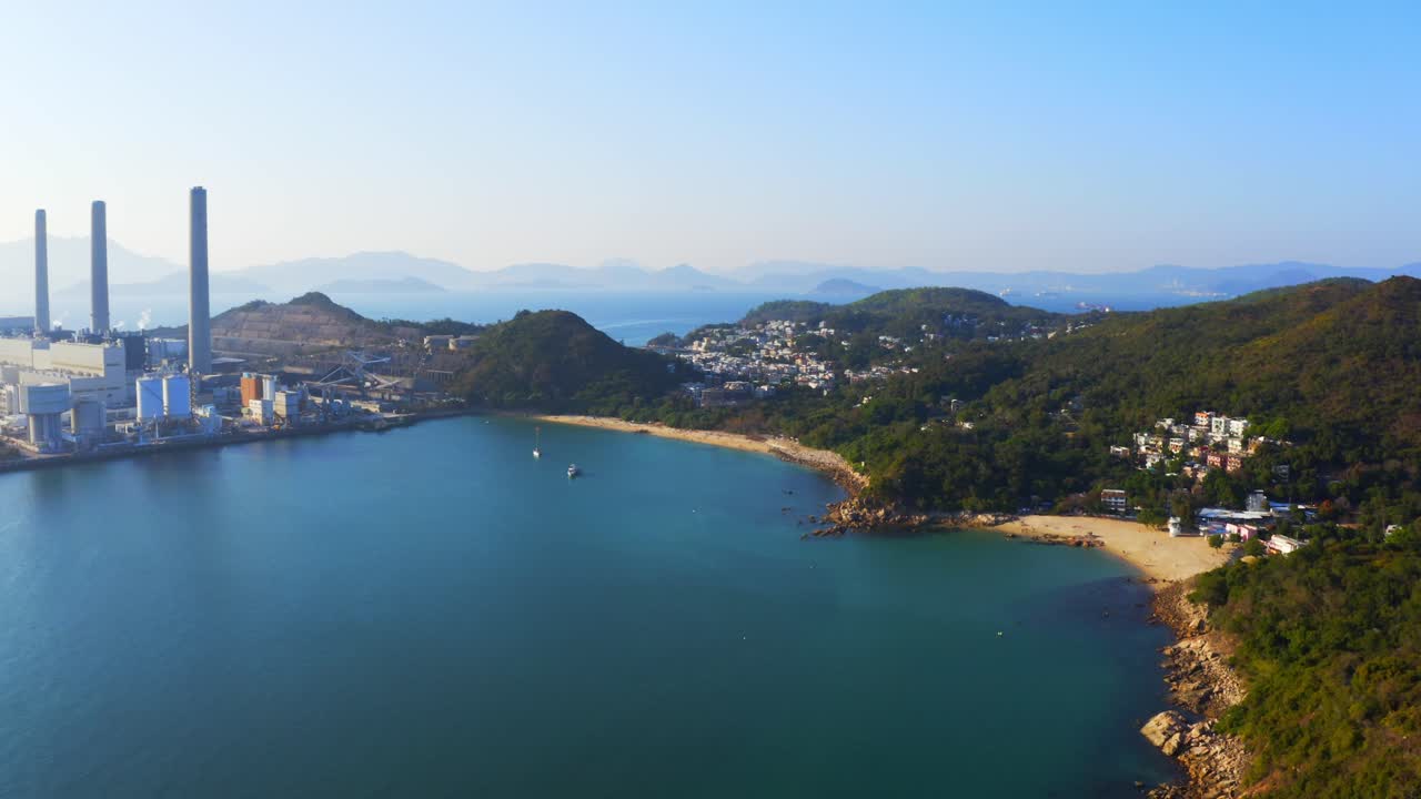 아름다운 화창한 날-2 동안 해변이 있는 마을 옆 섬에 있는 큰 해안 석탄 화력 발전소의 드론 샷