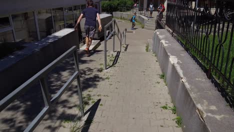 fast paced tracking shot of a young adult male parkour runner jumping vaulting and flipping down city stairs