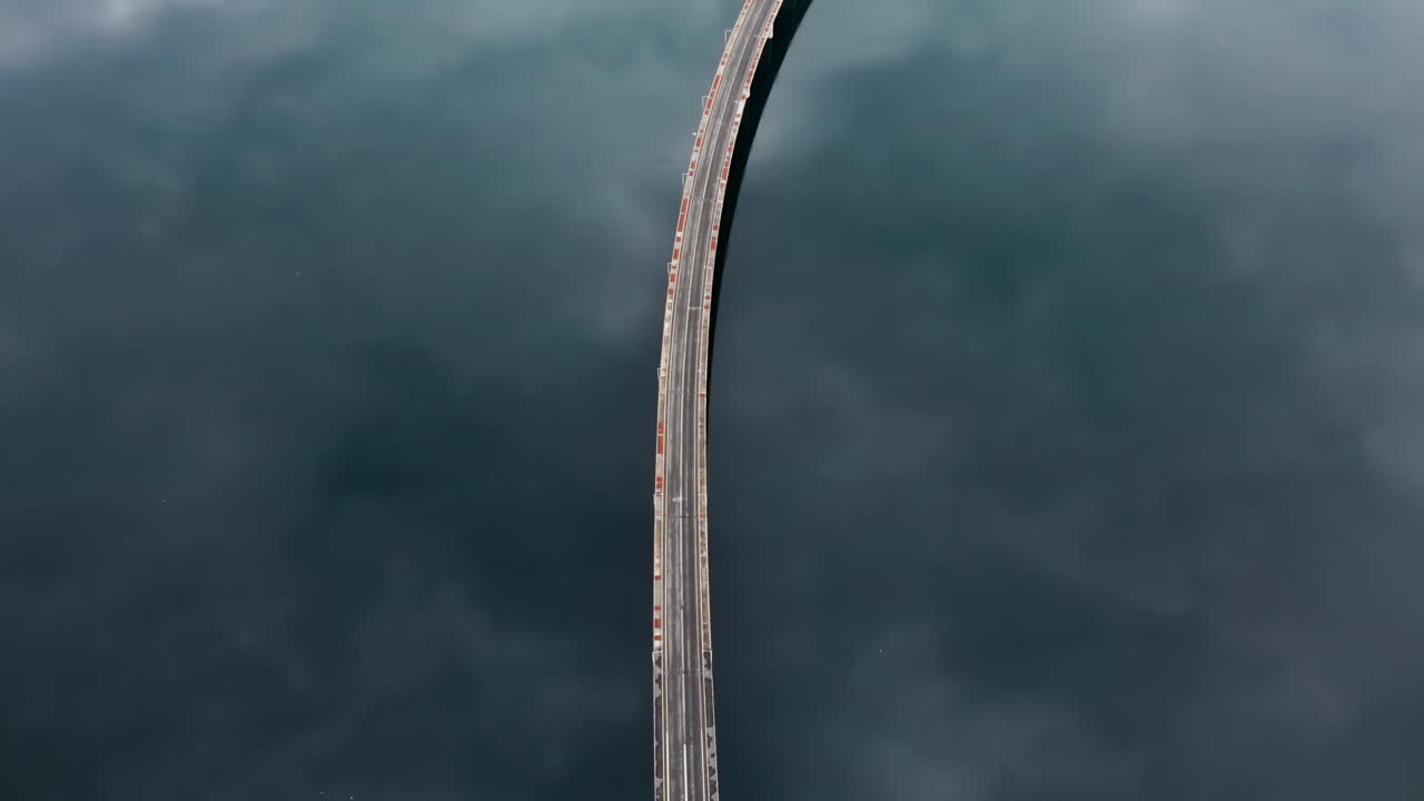 wide aerial View of High Bridge of Servia at Kozani GREECE its is a top down view of the bridge while tracking following cars reflection of the clouds at the lake and the bridge middle of the frame