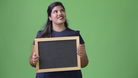 young overweight beautiful indian businesswoman against green background