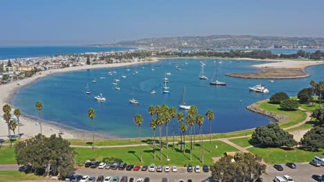 Drohnenaufnahme-In-Der-Bucht-Von-San-Diego-Mit-Segelbooten,-Die-Mit-Einem-Kleinen-Moror-Boot-Verankert-Sind,-Das-Sich-An-Ein-Großes-Segelboot-In-Kalifornien-Anschließt