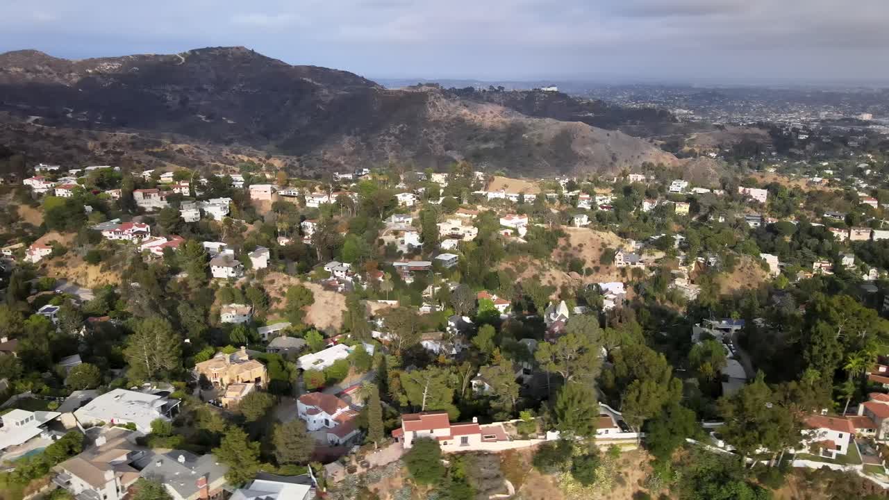 vista aérea volando a través de vasto residencial urbano bienes raíces hollywood campo montaña paisaje dolly derecha
