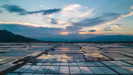 aerial hyper lapse showing moving clouds over salt fields during golden hour