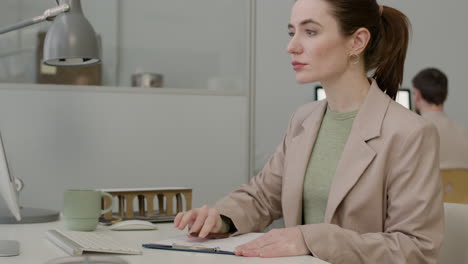 woman working using laptop sitting at desk in the office