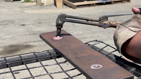 heat shimmering off a gas welding torch as it cuts a hole in a steel plate