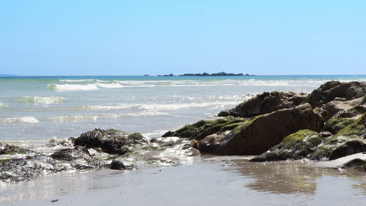 Le onde si infrangono sulle rocce coperte di muschio.
