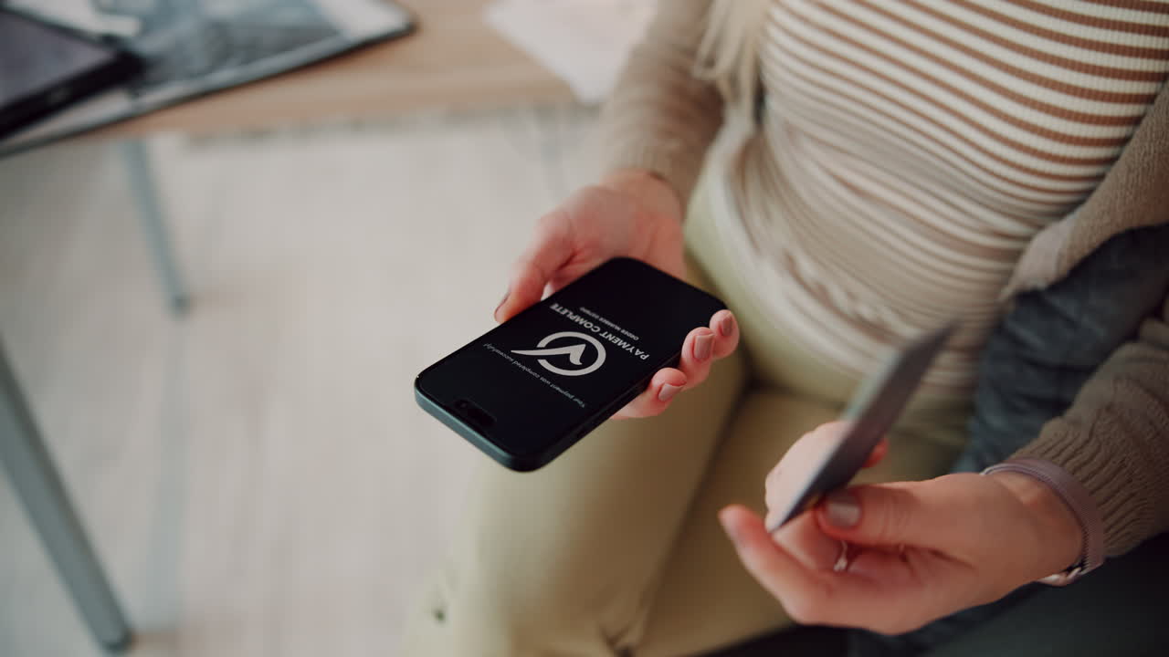 Woman using a smartphone to make a payment with a credit card
