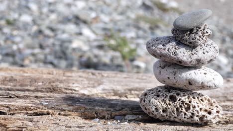 small textured beach rocks balanced zen like on wooden beach sleeper dolly right slow