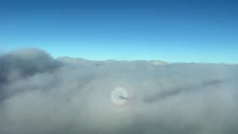 vista extraña de un halo de avión a reacción que sobrevuela y penetra en las nubes estratos durante el descenso