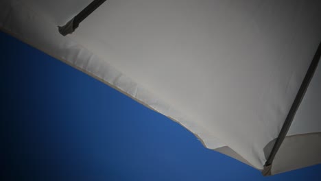 edge of a white umbrella moving by the wind