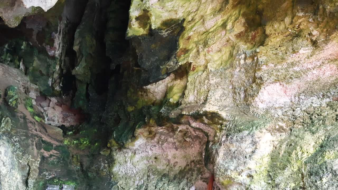 туристы посещают священную пещеру с красочными приношениями.