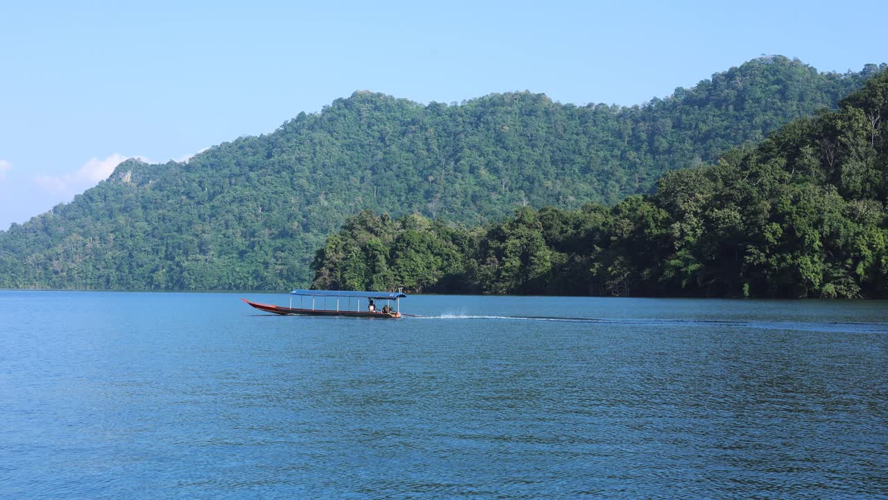 한 배가 조용하고 아름다운 호수를 가로질러 꾸준히 움직입니다.