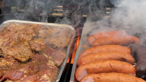 frying marinated pork and sausages on bbq grill outdoor in poland daytime