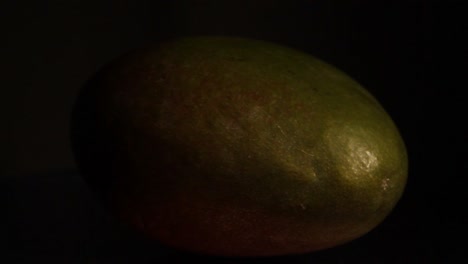 la luz se mueve hacia la derecha sobre la fruta del mango en la oscuridad