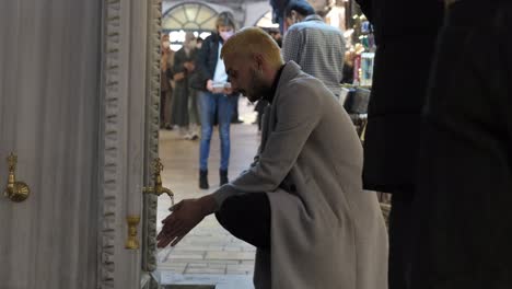 Junger-Mann-Wäscht-Seine-Hände-Am-Historischen-Brunnen