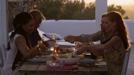 dos parejas cenando en una mesa en una terraza de la azotea, filmado en r3d