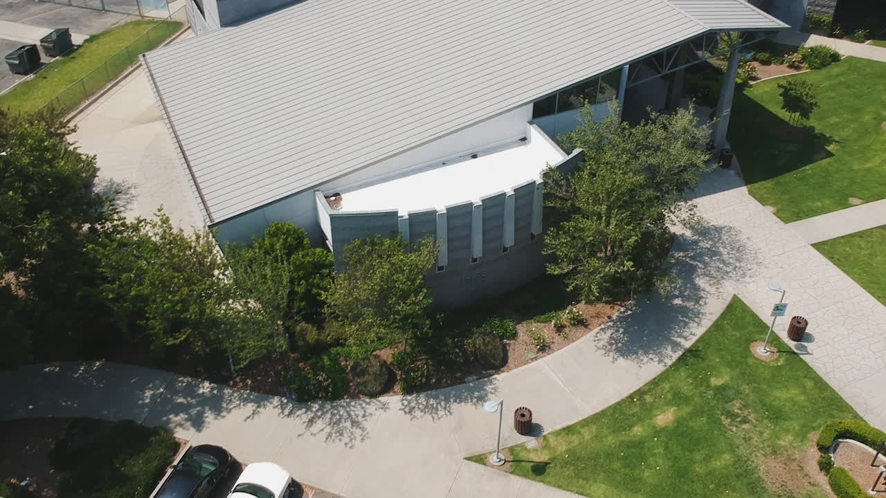 Drone footage of the community during the summer. School getting out, parents getting home, people enjoying the community center