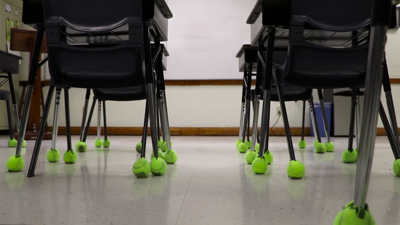 Slider push-in empty school classroom. Low angle desks on school campus