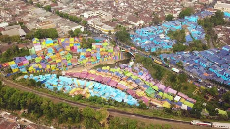 Colorido-Vuelo-Aéreo-De-La-Aldea-Mientras-El-Tren-Pasa-En-Un-Día-Cambiante,-Java-Oriental,-Indonesia