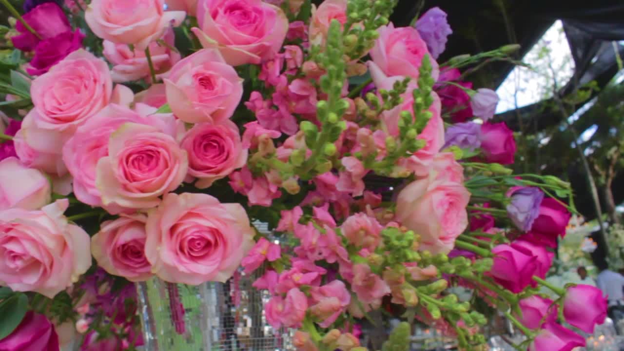 Flowers Arrangement with pink and purple roses in the table for a wedding