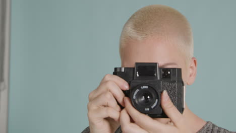 tracking shot orbiting around female photographer posing with vintage camera 03