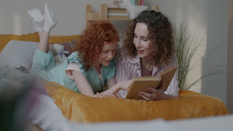 madre e hija leyendo juntos en una cama